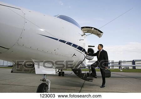Stock Image - Businessman boarding a private airplane. Fotosearch