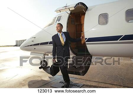 Businessman boarding a private airplane View Large Photo Image Stock Image - Businessman boarding a private airplane. Fotosearch