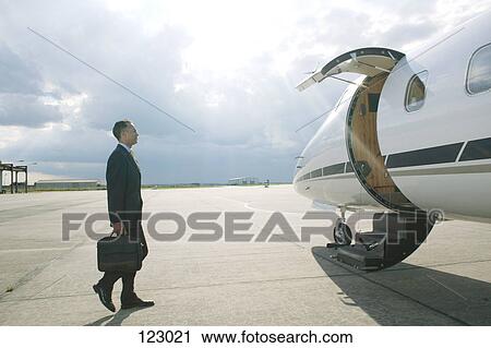Businessman boarding a private airplane View Large Photo Image Stock Image - Businessman boarding a private airplane. Fotosearch