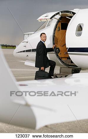 Businessman boarding a private airplane View Large Photo Image Stock Photo - Businessman boarding a private airplane. Fotosearch