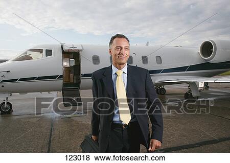 Businessman in front a private airplane View Large Photo Image Stock Photo - Businessman in front a private airplane. Fotosearch