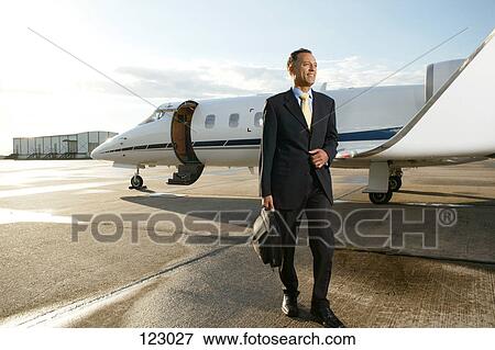 Stock Photo - Businessman in front of a private airplane. Fotosearch