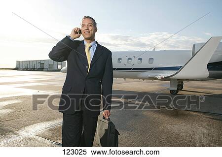 Businessman in front of a private airplane View Large Photo Image Stock Photography - Businessman in front of a private airplane. Fotosearch