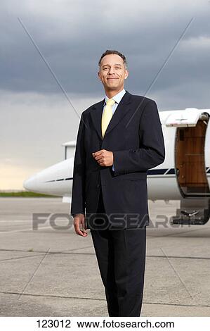Businessman posing in front of a private airplane View Large Photo Image Stock Image - Businessman posing in front of a private airplane. Fotosearch