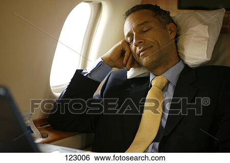 Stock Photograph - Businessman sleeping in an airplane. Fotosearch
