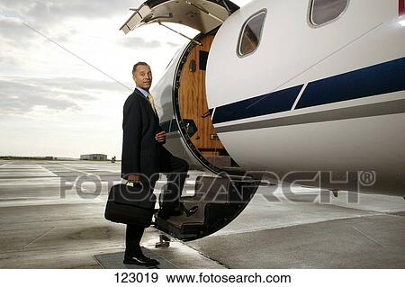 Businessman standing on a private airplane’s steps View Large Photo Image Stock Photo - Businessman standing on a private airplane’s steps. Fotosearch