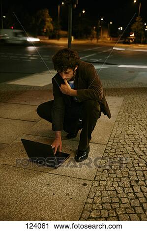 Man using laptop computer in the street View Large Photo Image Stock Image - Man using laptop computer in the street. Fotosearch