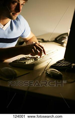 Stock Image - Man working at computer. Fotosearch