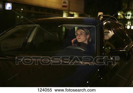 Stock Photography - Woman sitting in a car, using a mobile phone. Fotosearch