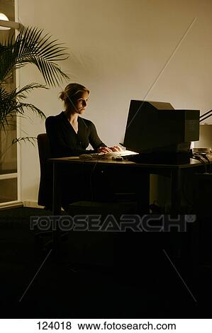 Stock Photo - Woman sitting in front of a computer. Fotosearch