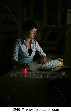 Woman using computer in the dark View Large Photo Image Stock Photo - Woman using computer in the dark. Fotosearch