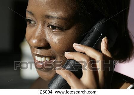 Portrait of woman listening to a telephone View Large Photo Image Picture - Portrait of woman listening to a telephone. Fotosearch