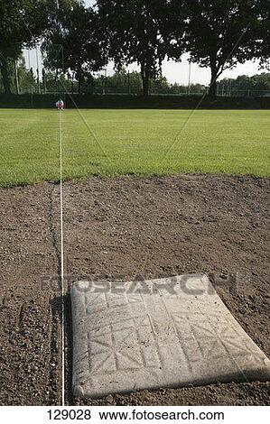 Baseball player aligning a base View Large Photo Image Stock Photo - Baseball player aligning a base. Fotosearch
