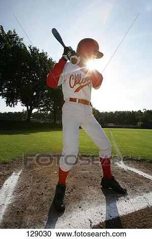 Stock Image - Baseball player holding a baseball bat. Fotosearch
