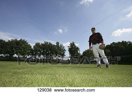 Stock Photo - Baseball player standing in the outfield. Fotosearch