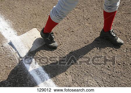 Stock Image - Baseball player standing on a base. Fotosearch