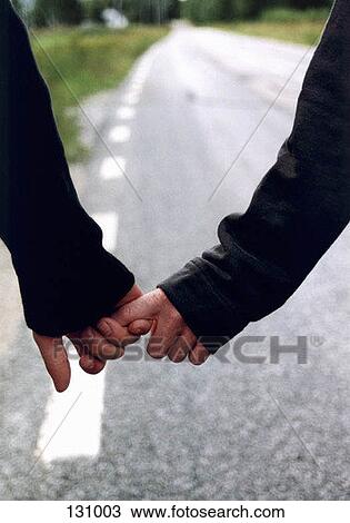 Stock Image - Close-up of a man and woman holding hands. Fotosearch