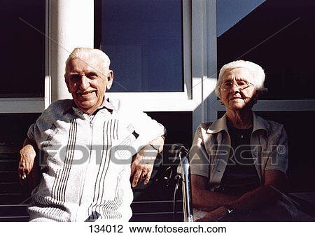 Stock Image - Senior couple sitting outdoors. Fotosearch