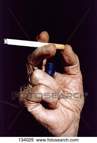 Senior man holding a cigarette View Large Photo Image Stock Photo - Senior man holding a cigarette. Fotosearch