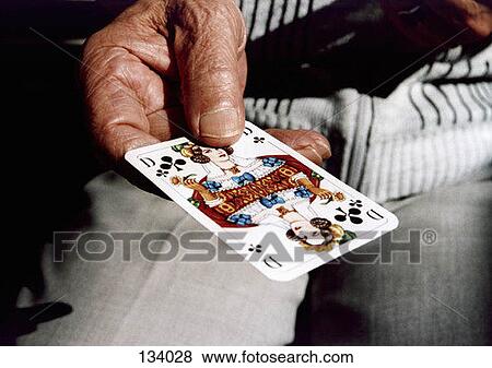 Senior man holding a playing card View Large Photo Image Stock Photo - Senior man holding a playing card. Fotosearch