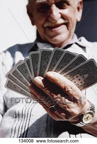 Senior man holding playing cards View Large Photo Image Stock Photo - Senior man holding playing cards. Fotosearch