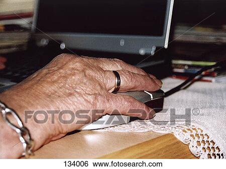 Senior woman using a computer mouse View Large Photo Image Stock Photograph - Senior woman using a computer mouse. Fotosearch