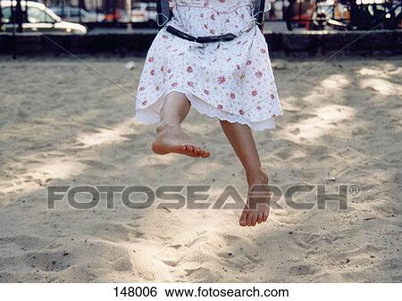 A young girl swinging on a playground View Large Photo Image Stock Photograph - A young girl swinging on a playground. Fotosearch
