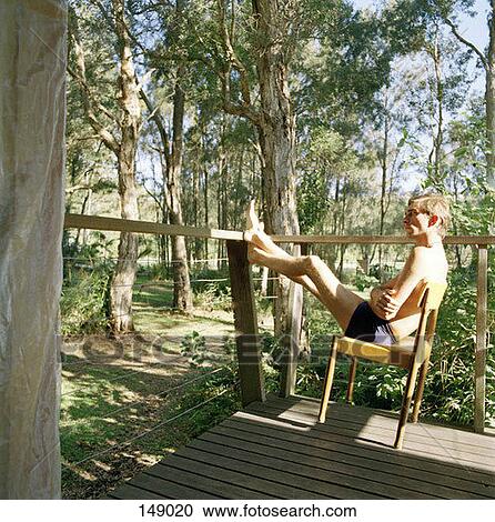 A man relaxing in a chair on a porch View Large Photo Image Stock Image - A man relaxing in a chair on a porch. Fotosearch
