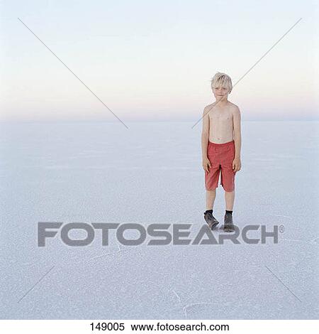 A young boy standing on a frozen lake View Large Photo Image Stock Photography - A young boy standing on a frozen lake. Fotosearch