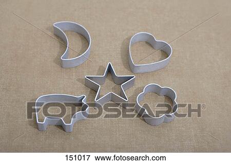 Five cookie cutters on a brown surface View Large Photo Image Stock Photo - Five cookie cutters on a brown surface. Fotosearch