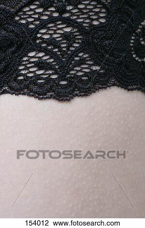 Stock Image - Close of embroidered material on skin. Fotosearch