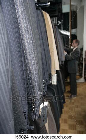 Picture - A man shopping for a suit in a clothing shop. Fotosearch