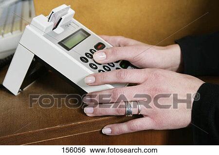 A woman operating a credit card machine View Large Photo Image Stock Photograph - A woman operating a credit card machine. Fotosearch