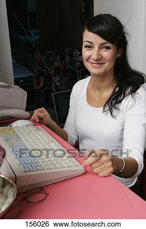 A woman sitting at a cash register View Large Photo Image Stock Photograph - A woman sitting at a cash register. Fotosearch