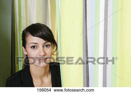 A woman standing next to a changing room curtain View Large Photo Image Picture - A woman standing next to a changing room curtain. Fotosearch