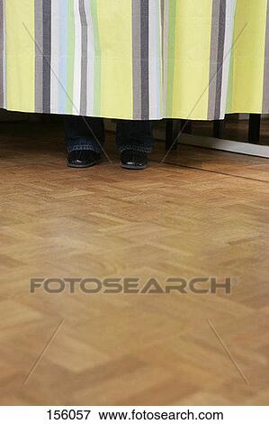 Front view of human feet behind a dressing room curtain View Large Photo Image Stock Photo - Front view of human feet behind a dressing room curtain. Fotosearch
