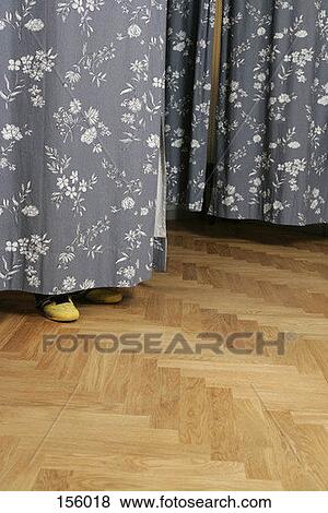 Side view of human feet beneath a dressing room curtain View Large Photo Image Stock Photo - Side view of human feet beneath a dressing room curtain. Fotosearch
