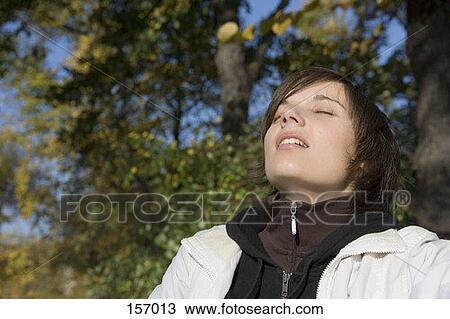 A young woman closing her eyes View Large Photo Image Stock Image - A young woman closing her eyes. Fotosearch
