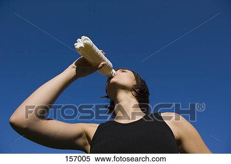 Stock Photography - A young woman drinking from a bottle. Fotosearch