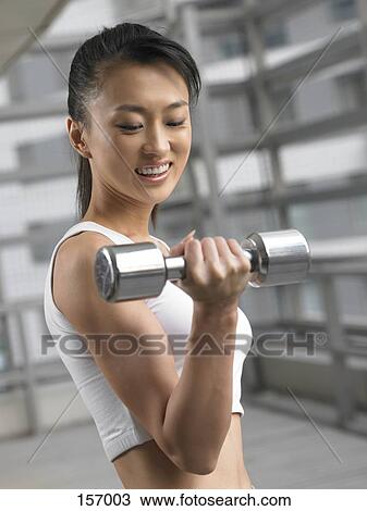 Stock Image - A young woman flexing her muscles. Fotosearch