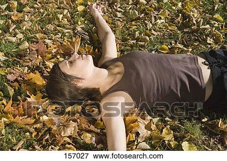 A young woman lying in the grass View Large Photo Image Stock Photo - A young woman lying in the grass. Fotosearch