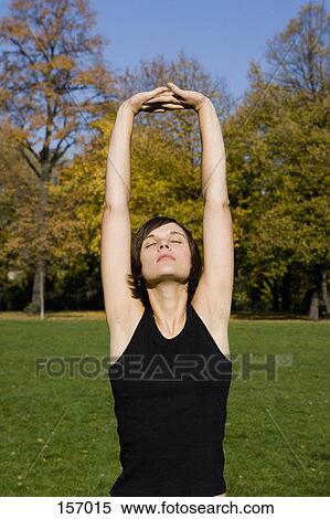 Front view of a young woman stretching her arms View Large Photo Image Stock Photography - Front view of a young woman stretching her arms. Fotosearch