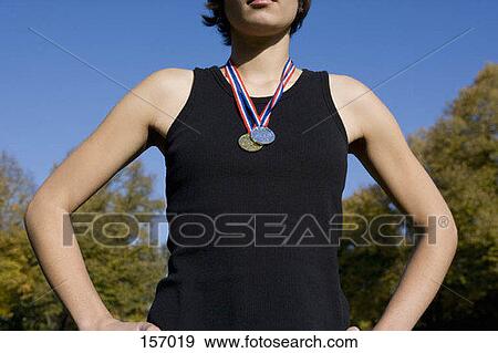 Stock Photo - Front view of a young woman wearing gold and silver medals. Fotosearch