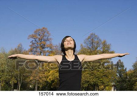 Front view of a young woman with outstretched arms View Large Photo Image Picture - Front view of a young woman with outstretched arms. Fotosearch
