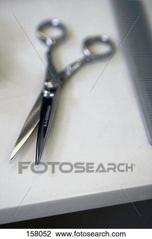 A pair of scissors and a comb on a table View Large Photo Image Stock Image - A pair of scissors and a comb on a table. Fotosearch