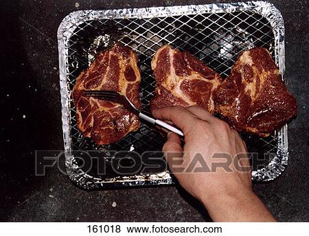 A man cooking steak on a grill View Large Photo Image Stock Photo - A man cooking steak on a grill. Fotosearch