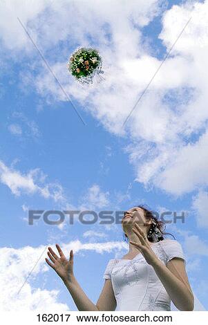 Low angle view of a bride tossing a bouquet of flowers View Large Photo Image Stock Photo - Low angle view of a bride tossing a bouquet of flowers. Fotosearch