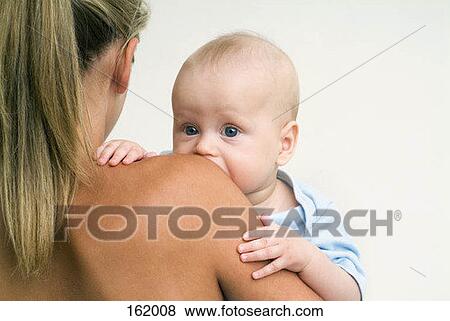Stock Photo - Rear view of a woman carrying a baby. Fotosearch