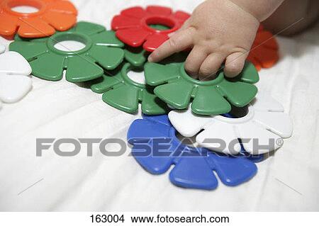 A baby playing with colorful plastic toys View Large Photo Image Picture - A baby playing with colorful plastic toys. Fotosearch
