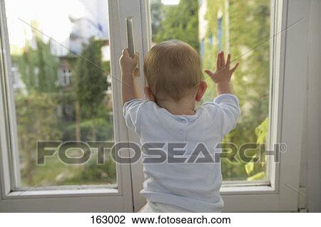 Rear view of a baby trying to open a window View Large Photo Image Stock Image - Rear view of a baby trying to open a window. Fotosearch